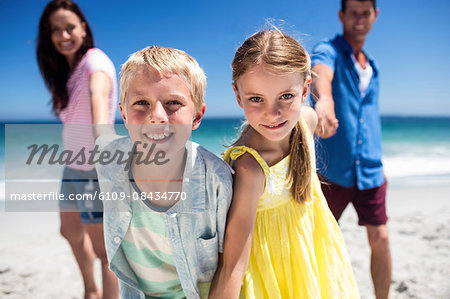 Cute family holding hands on the beach