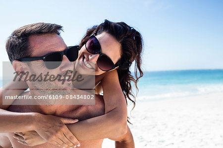 Cute couple hugging with arms around on the beach