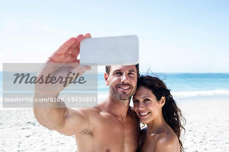 Cute couple taking selfie on the beach