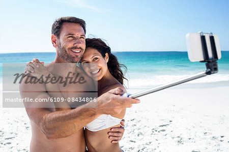 Cute couple taking selfie on the beach