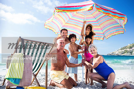 Cute family setting their umbrella on the beach