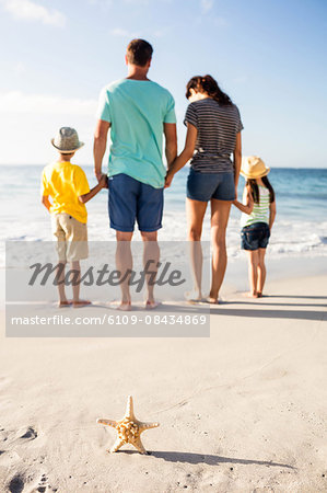 Cute family standing in the sand on the beach