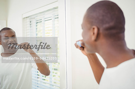 Handsome man about to brush his teeth in the bathroom