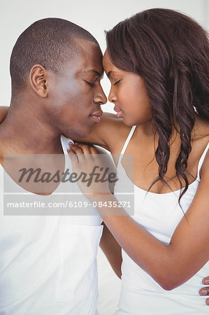 Ethnic couple with forehead against forehead in their room