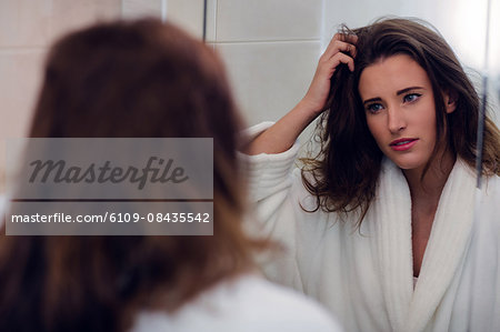 Beautiful brunette with messy hair and bathrobe in the bathroom