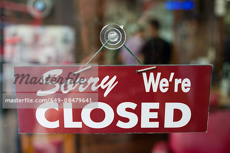 View through window of closed sign in shop