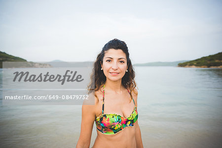 Woman wearing bikini top, sea in background