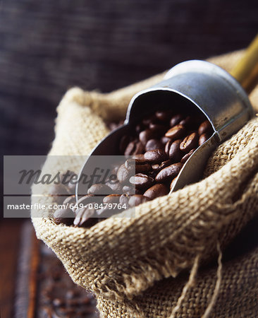 Coffee beans in woven sack with vintage coffee scoop