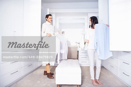 Young couple making decisions whilst getting ready  in bedroom