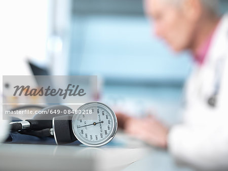 Blood pressure monitor on desk, doctor in background