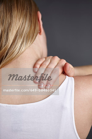 Cropped close up shot of young womans hand massaging her own shoulder Cropped close up shot of young womans hand massaging her own shoulder