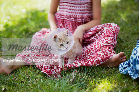 Girl with cat wearing protective collar