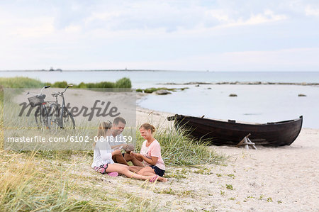 Family playing cards on beach Family playing cards on beach