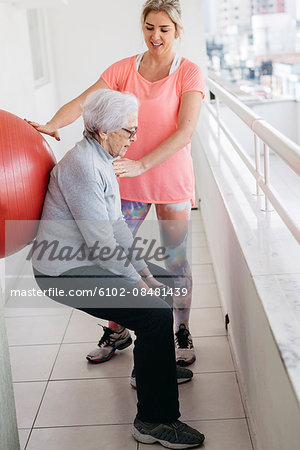 Senior woman exercising with fitness instructor