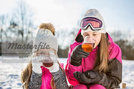 Mother and daughter drinking tea on a beautiful snowy day