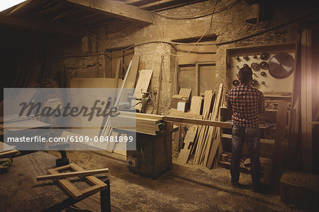 Carpenter working on his craft in a dusty workshop