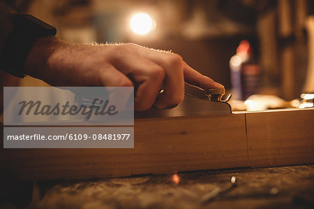 Carpenter working on his craft in a dusty workshop