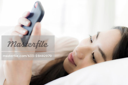 Woman lying down, using smartphone
