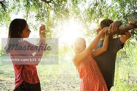 Young woman photographing her friends