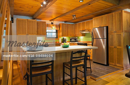 Wooden kitchen island with ceramic counter in Canadian cottage style log home