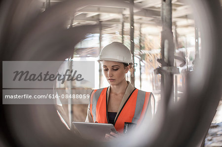Female builder using digital tablet on construction site