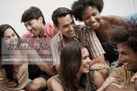 Six young people, three men and three women, laughing.