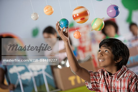 A boy looking up at a display of the planets, a presentation of the planetary system.