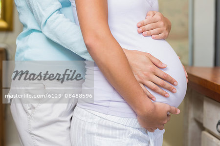 Close up view of a lesbian pregnant couple touching stomach