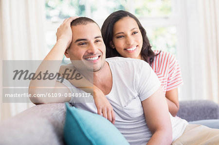 Happy couple hugging on the couch at home