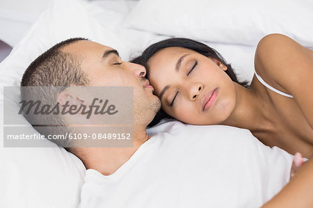 Young couple sleeping in the bed at home in the bedroom