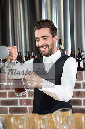 Barman pouring beer in a pub