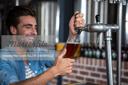 Barman pouring beer in a pub