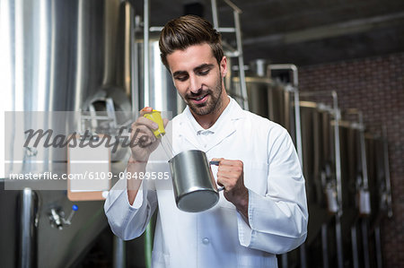 Focused brewer testing his beer at the microbrewery Focused brewer testing his beer at the microbrewery