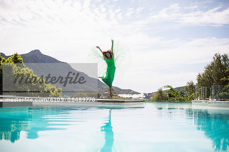 Elegant woman dancing by the pool on a summers day