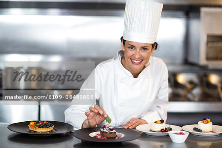 Chef putting finishing touch on dessert in a commercial kitchen