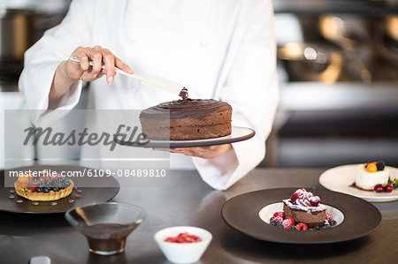 Chef putting finishing touch on dessert in a commercial kitchen