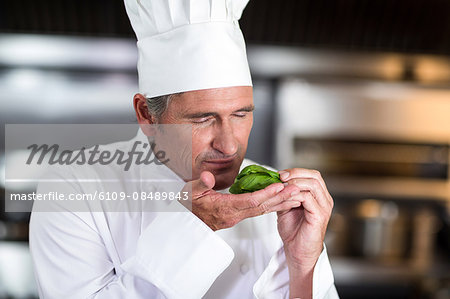 Chef smelling fresh basil in a commercial kitchen