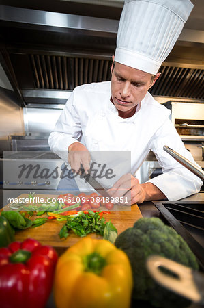 Chef preparing vegetables at counter in a commercial kitchen