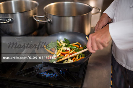 Chef making a stir fry in a commercial kitchen