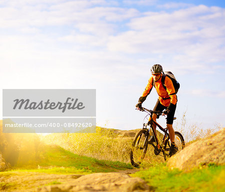 Cyclist Riding the Bike on the Morning Mountain Trail