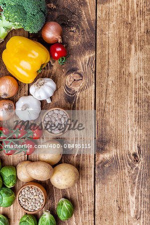 Fresh and healthy organic vegetables and food ingredients on wooden background