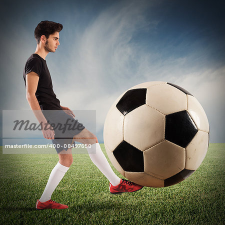 Teenage soccer player plays with big soccerball