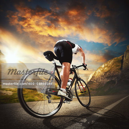 Cyclist rides on the road between mountains