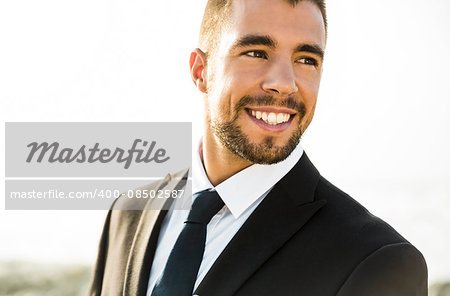 Good look young man in outdoor wearing a suit and smiling