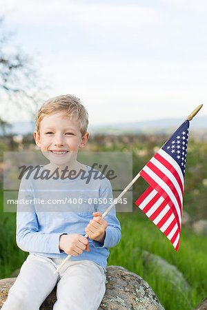 smiling boy holding american flag and celebrating 4th of july