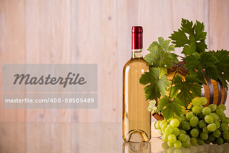 Bottle of wine with a barrel and grapes and grapeleaves