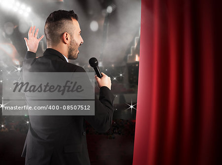 Man talking on microphone on theater stage