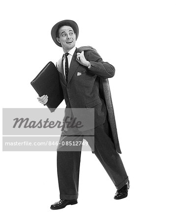 1950s SALESMAN BUSINESSMAN BRIEFCASE HAT WALKING COAT OVER SHOULDER SMILING EXPRESSION LOOKING BACK OVER SHOULDER AT COMPETITION