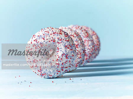 Doughnuts with white icing and colourful sugar sprinkles