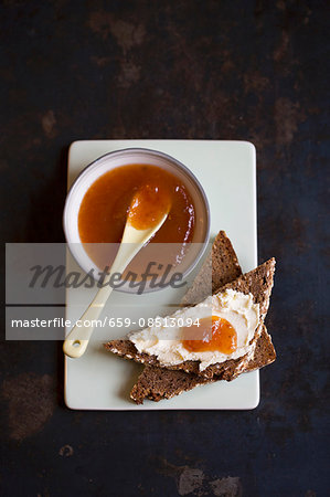 Medlar jam on a bowl and on a slice of toast with cream cheese (seen from above)